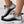 Zwart-witte sneakers met gebreid patroon en dikke zool, versierd met gouden enkelbandjes. Trendy damesmode, comfortabele sportschoenen.