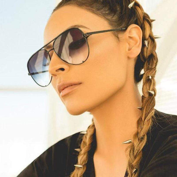 Vrouw met aviator zonnebril, vlechten met spikes, modieuze zonnebrillen, boho stijl, zomermode, trendy accessoires, zwart montuur.