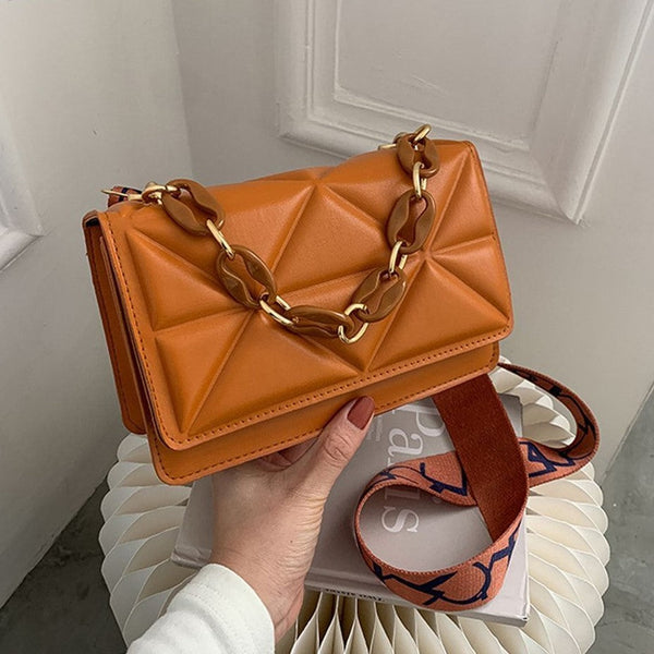 Bruine leren handtas met geometrisch patroon, gouden kettingriem en verstelbare schouderband. Stijlvolle damesaccessoire voor dagelijks gebruik.