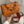 Oranje leren handtas met geometrisch patroon, goudkleurige ketting en verstelbare schouderriem. Trendy damesaccessoire voor dagelijks gebruik.