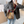 Vrouw met bruine handtas met rode schouderband, gestreept patroon. Modieuze outfit met grijze blazer en spijkerbroek. Accessoire, damesmode.