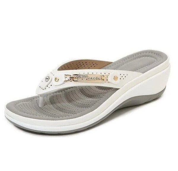 Witte orthopedische damesslipper met sleehak, comfortabele zool en decoratieve metalen details. Ideaal voor zomerse casual outfits.