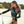 Vrouw in bloemen wetsuit op strand met surfplank, zomerse surfkleding, strandmode, surfuitrusting, dames wetsuit, strandvakantie.