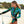 Vrouw in kleurrijk surfpak met tropisch bladpatroon houdt surfplank vast op zonnig strand. Perfect voor zomerse surfmode en strandactiviteiten.