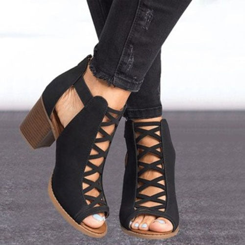 Zwarte open teen hakken met veters, houten blokhak en gescheurde zwarte jeans. Trendy damesmode, stijlvolle zomerschoenen.