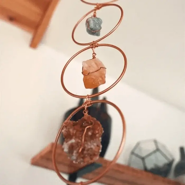 Koperen chakra decor met drie ruwe kristallen, hangend aan de muur. Spirituele woondecoratie, energieversterking, meditatieaccessoire.