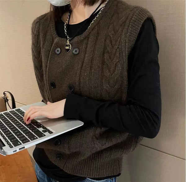 Vrouw met bruine gebreide spencer en zwarte trui werkt op laptop. Mode, herfstkleding, casual stijl, technologie, thuiswerken.