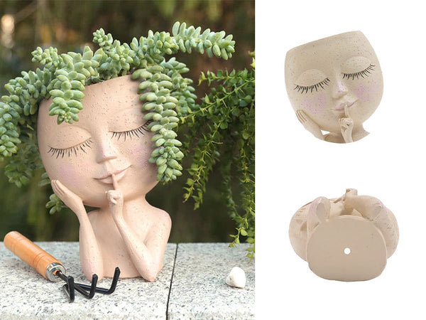 Decoratieve plantenpot in de vorm van een gezicht met gesloten ogen, gevuld met groene vetplanten. Perfect voor tuin- en interieurdecoratie.