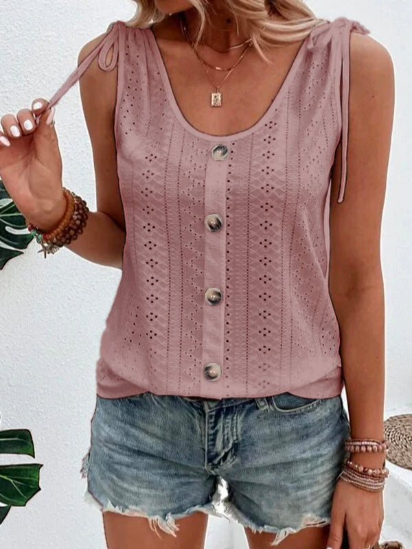 Vrouw draagt roze mouwloze top met knoopsluiting en kanten details, gecombineerd met denim shorts. Zomerse mode, casual outfit, dameskleding.