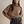 Vrouw in stijlvolle bruine coltrui met zwarte accenten, gecombineerd met grijze broek en zwarte riem. Modieuze herfstkleding, elegant design.