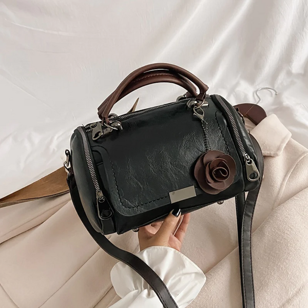 Zwarte leren handtas met bruine handgreep en roosdetail, stijlvolle damesmodeaccessoire, perfect voor dagelijks gebruik en elegante outfits.