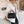 Vrouw in witte blazer met zwarte leren handtas en koffiebeker, moderne mode, stijlvolle accessoires, casual chique look, binnenomgeving.