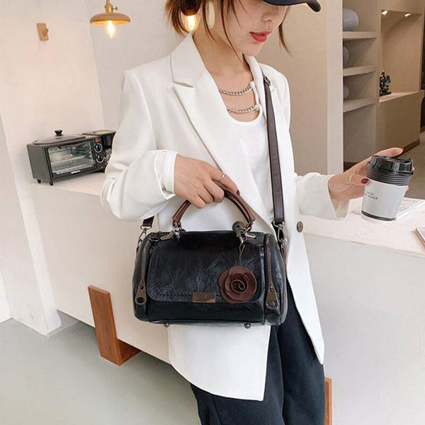 Vrouw in witte blazer met zwarte leren handtas en koffiebeker, moderne mode, stijlvolle accessoires, casual chique look, binnenomgeving.