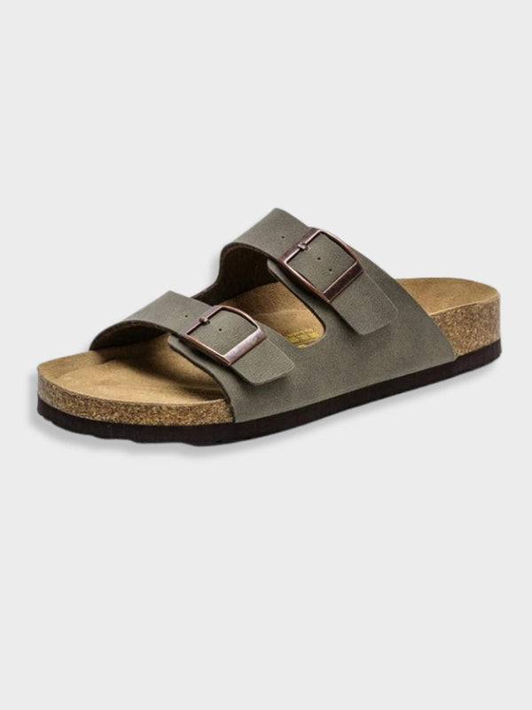 Donkergrijze leren sandaal met kurken zool en dubbele verstelbare gespen, ideaal voor comfort en casual stijl. Perfecte zomerschoen.