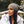 Vrouw met grijze beanie en witte winterjas, buiten in herfstomgeving. Modieuze winterkleding, trendy accessoires, herfstmode.