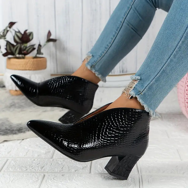 Zwarte leren enkellaarsjes met krokodillenprint en blokhak, gedragen met blauwe skinny jeans. Stijlvolle damesmode, trendy schoenen.