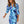 Vrouw in blauwe geometrische printjurk, modetrend 2023, stijlvolle kleding, elegante damesmode, moderne outfit, chique design, casual chic.