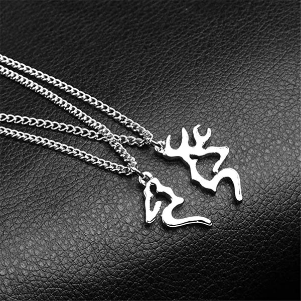 Twee zilveren hertenkettingen op zwart leer, sieraden met hertensilhouet, modieuze accessoires, perfect voor natuurliefhebbers en dierenliefhebbers.