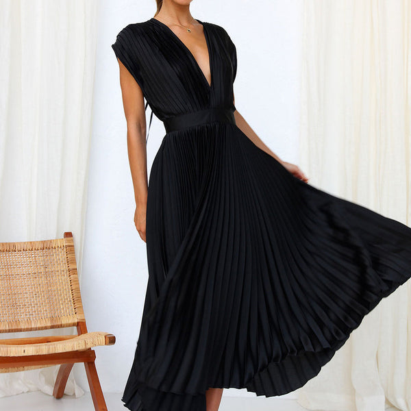 Elegante zwarte geplooide jurk met diepe V-hals, gedragen door model. Perfect voor avondkleding. Stijlvolle mode, chique design, tijdloze elegantie.
