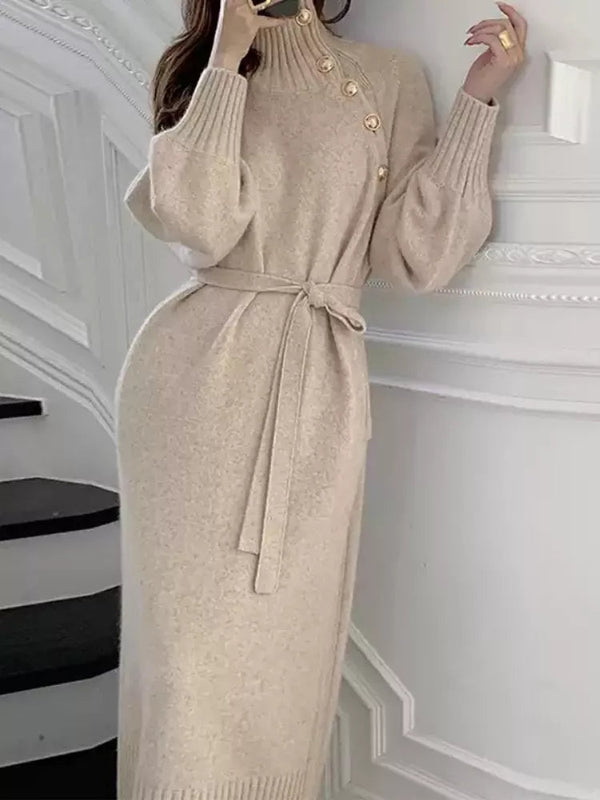 Vrouw in elegante beige gebreide jurk met knopen en ceintuur, staand op trap. Modieuze winterkleding, stijlvolle damesmode, comfortabele pasvorm.