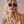 Vrouw met blonde haren draagt zwarte zonnebril en bloemenbikini. Stijlvolle zomerlook, modieuze accessoires, trendy damesmode.