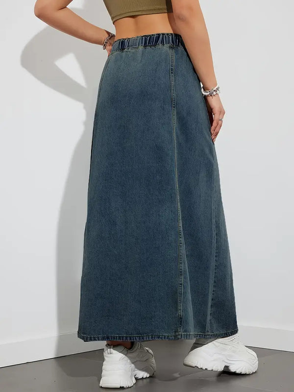 Dames denim maxi rok, hoge taille, casual stijl, blauwe spijkerstof, gecombineerd met witte sneakers en groene top, modieuze outfit.