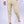 Beige chino broek voor heren, gecombineerd met witte sneakers en een wit overhemd. Stijlvolle casual outfit, ideaal voor moderne herenmode.
