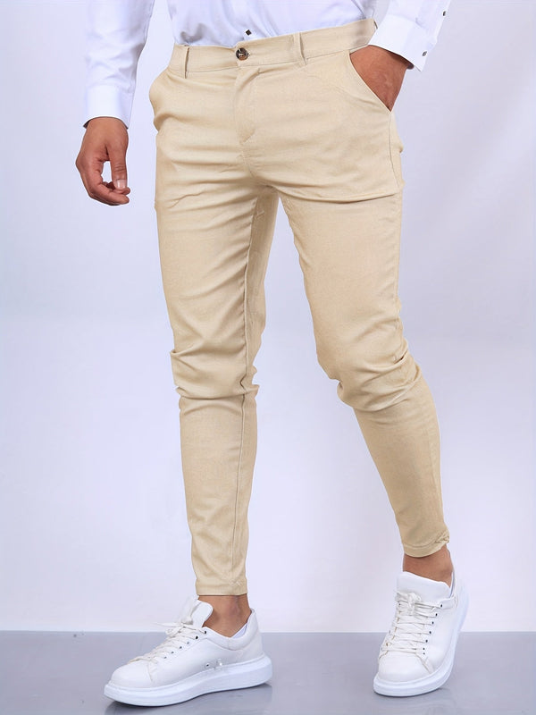 Beige chino broek voor heren, gecombineerd met witte sneakers en een wit overhemd. Stijlvolle casual outfit, ideaal voor moderne herenmode.