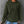 Vrouw in groene geribbelde hoodie met capuchon, draagt blauwe jeans en houdt een zwarte thermosbeker vast. Casual mode, herfstkleding, comfortabele stijl.