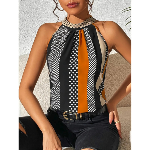 Vrouw draagt mouwloze top met geometrisch patroon in zwart, wit en oranje, gecombineerd met zwarte jeans. Modieuze dameskleding, trendy zomeroutfit.