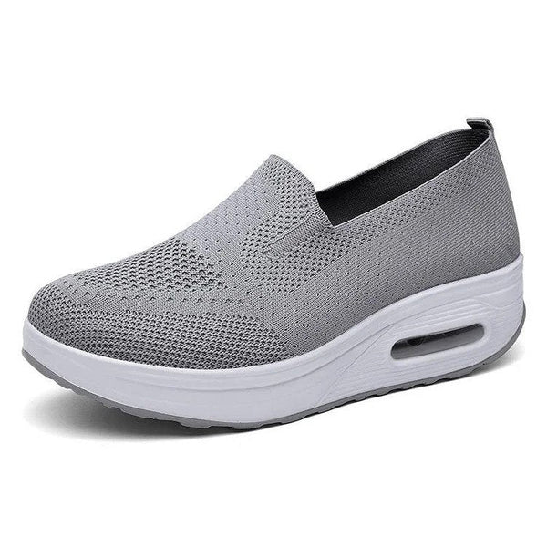 Grijze dames sneaker met ademend mesh bovenwerk en verhoogde witte zool, ideaal voor dagelijks comfort en stijl.