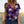 Vrouw draagt kleurrijk bloemen T-shirt met viooltjesprint, casual zomeroutfit, modetrend, buiten in zonnebloemveld.