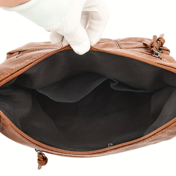 Bruine leren schoudertas met ritssluiting, open binnenkant zichtbaar, stijlvolle dameshandtas, modieus accessoire, hoogwaardige afwerking.