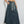 Vrouw in denim maxi-rok met elastische tailleband en witte sneakers, casual mode, trendy dameskleding, comfortabele streetwear-stijl.