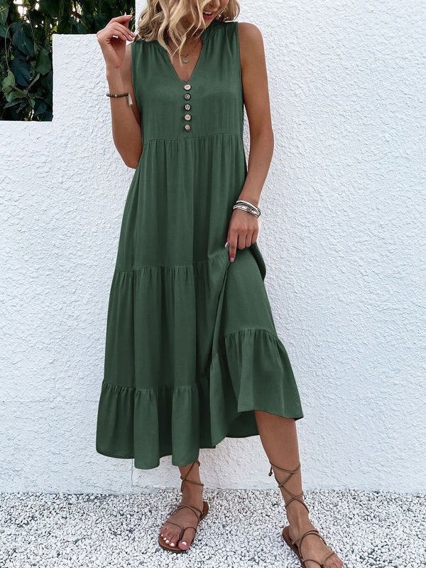 Groene zomerjurk met knopen, mouwloos en met ruches, gedragen door vrouw. Perfect voor casual zomeroutfits. Trendy damesmode 2023.