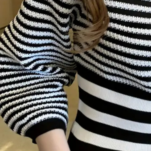 Gestreepte zwart-witte trui met lange mouwen, close-up. Modieuze dameskleding, casual stijl, comfortabele stof.