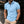 Man in lichtblauw poloshirt met korte mouwen, zwarte knopen en beige broek, poseert buiten. Modieuze herenkleding, casual stijl.