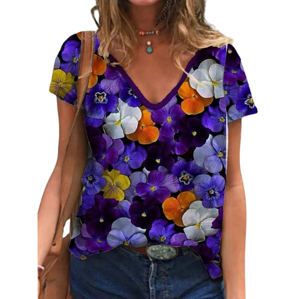 Vrouw draagt kleurrijk T-shirt met viooltjesprint, paarse en oranje bloemen, casual mode, zomerkleding, trendy dameskleding.