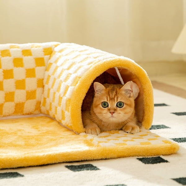 Pluche kattenbed en tunnel in één, geel geruit ontwerp, met kat erin. Ideaal voor kattenliefhebbers, huisdieraccessoires, comfortabele kattenplek.