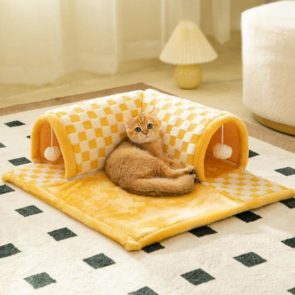Pluche kattenbed en tunnel in één, geel geruit ontwerp met pompons, comfortabele speelplek voor katten, ideaal voor binnengebruik.