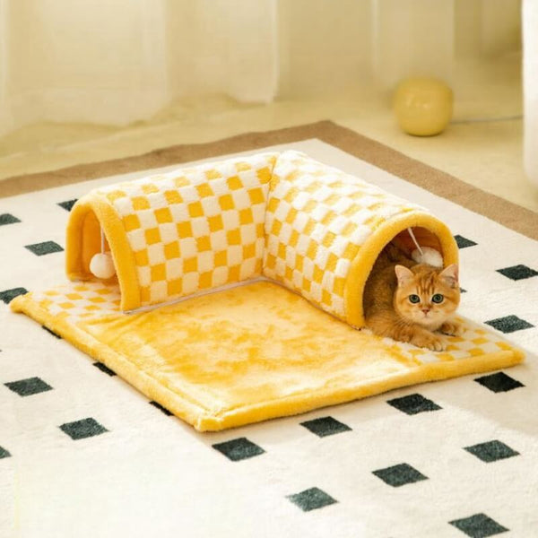 Gele geruite kattenbed en tunnel combinatie op een tapijt, met een kat erin. Perfect voor huisdieren, multifunctioneel kattenmeubel, comfortabel en stijlvol.