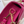 Roze leren handtas met gouden ketting en sluiting, stijlvolle damesaccessoire, close-up van zijkant, modieuze tas voor dagelijks gebruik.