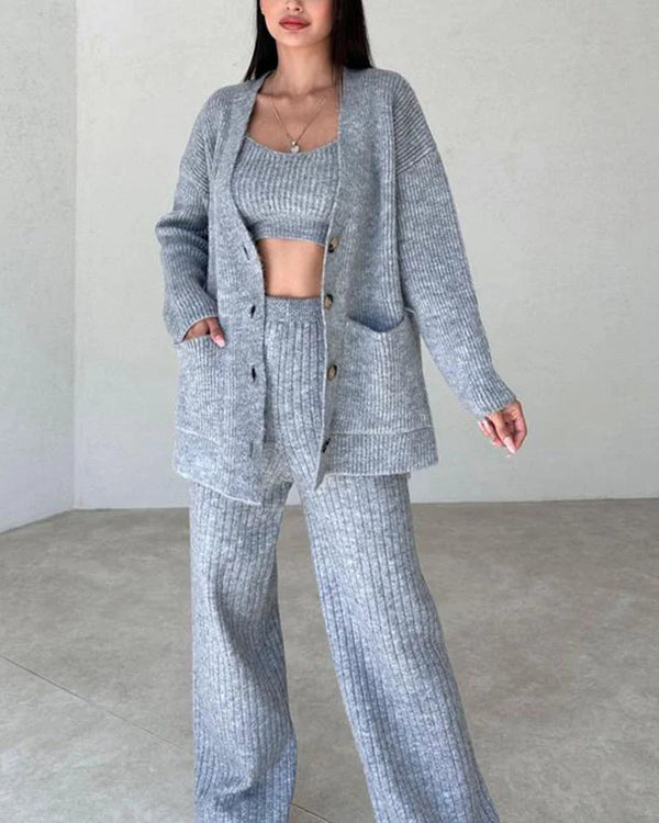 Grijze gebreide dames lounge set, bestaande uit een vest, crop top en wijde broek. Comfortabele en stijlvolle huisoutfit voor dagelijks gebruik.