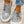 Grijze canvas instappers met dierenprint, gedragen door persoon in gescheurde jeans. Trendy casual schoenen voor dames, comfortabel en stijlvol.