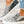 Grijze canvas instappers met dierenprint en witte zool, gedragen met gescheurde jeans. Trendy en casual schoenen voor dames.