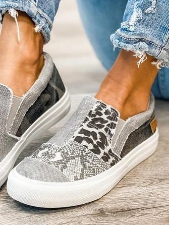 Grijze canvas instappers met dierenprint, trendy en comfortabel, gedragen met gescheurde jeans. Perfecte casual schoenen voor dagelijks gebruik.