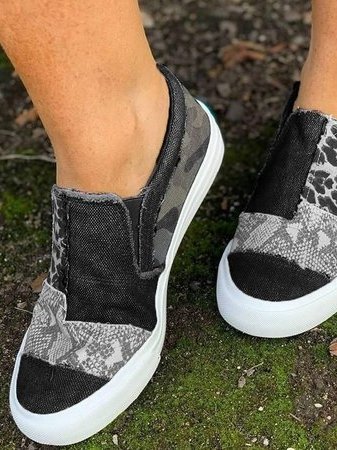 Zwarte canvas instappers met camouflage- en dierenprint, witte zool. Trendy damesschoenen voor casual stijl. Comfortabele slip-on sneakers.
