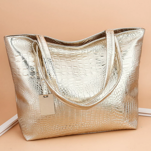 Gouden krokodillenleren handtas met dubbele schouderbanden en label, stijlvolle damesaccessoire, luxe mode, trendy tasontwerp.