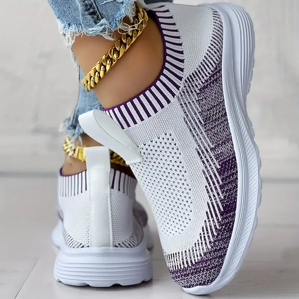 Witte en paarse gebreide sneakers met dikke zool, gedragen met gouden enkelband en gescheurde jeans. Comfortabele damesmode, trendy schoenen.