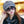 Vrouw met grijze flat cap en grote zonnebril, draagt een zwarte sjaal. Stijlvolle herfstmode, trendy accessoires, casual chique look.